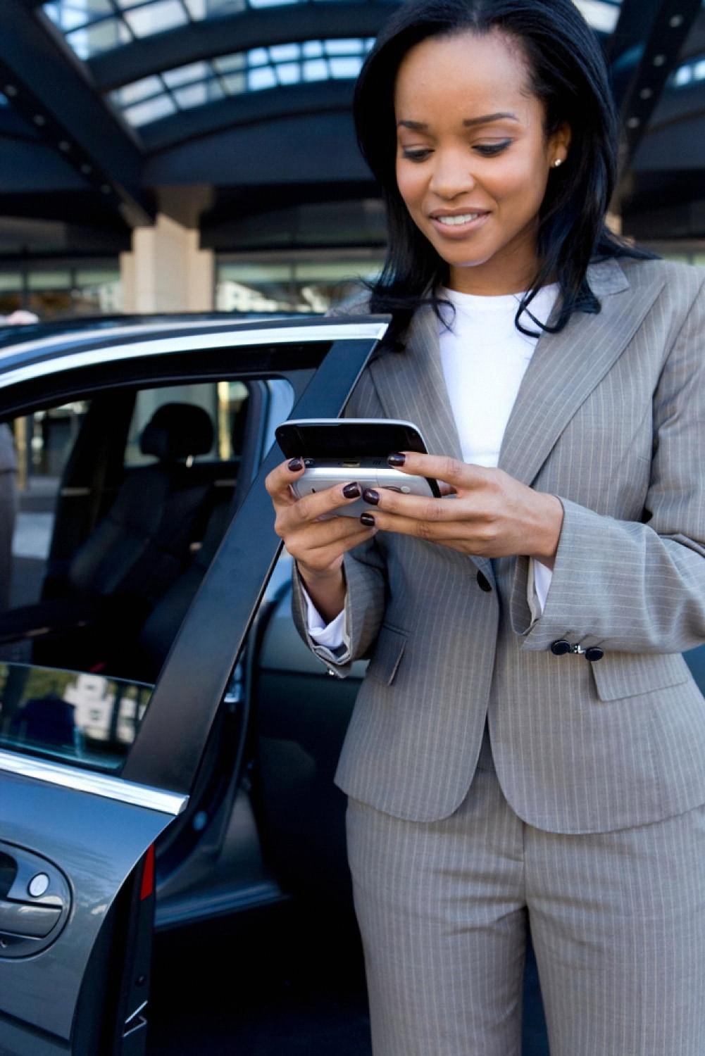 Business traveller using a smartphone for mobile hotel check-in outside a UAE hotel